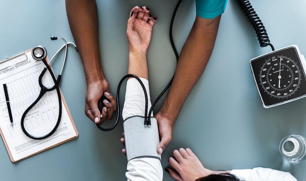 medical professional checking patient blood pressure