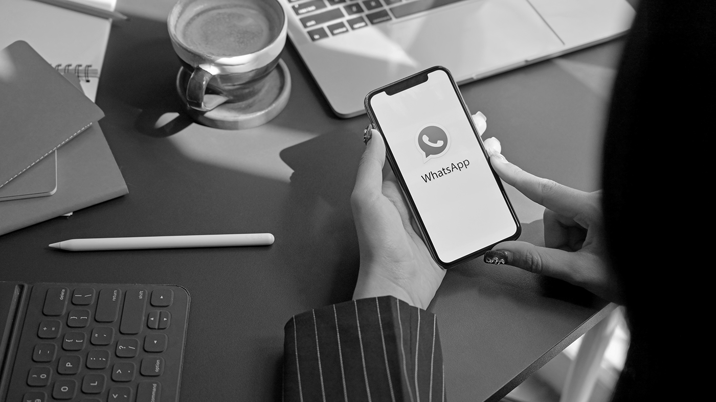 Business woman holding iPhone with WhatsApp screen
